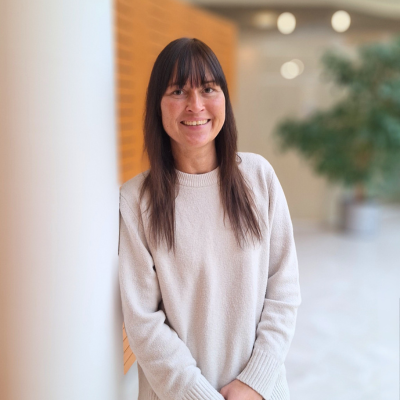 Eine Mitarbeiterin, die in die Kamera lächelt